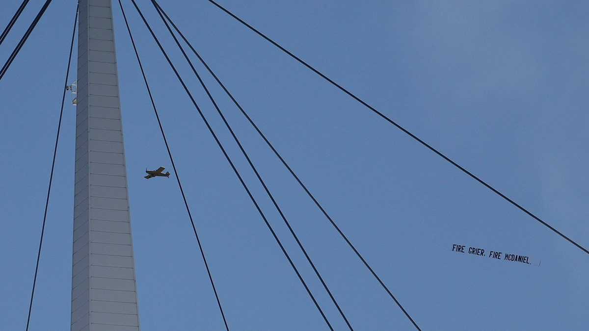 Fans display a banner calling for firings