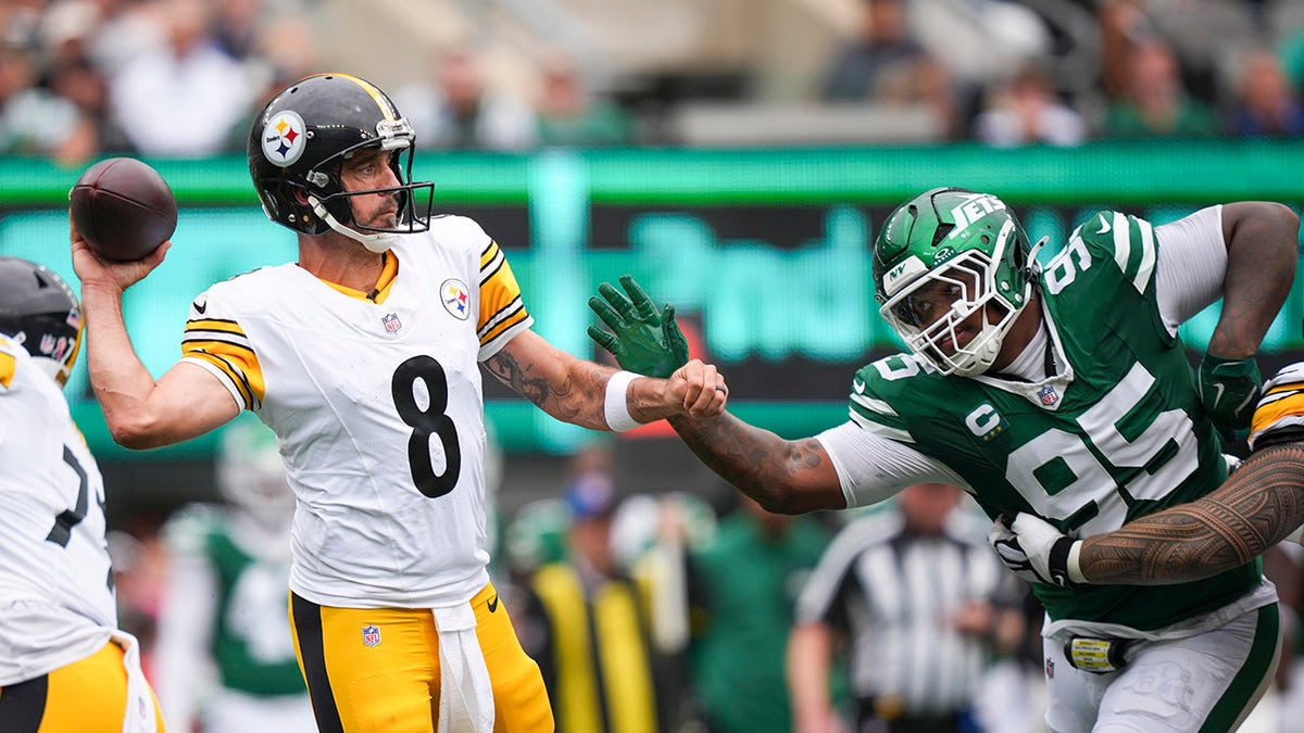 Rodgers throws as Jets defensive tackle Quinnen Williams pressures him