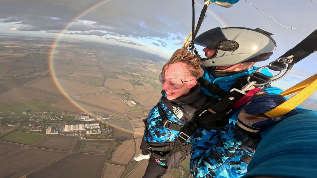 Skydivers beside rare circular rainbow