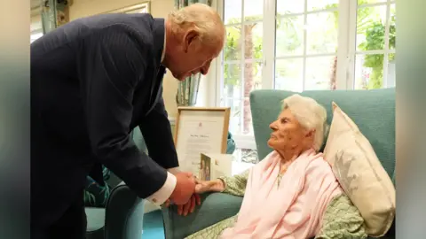 King Charles meets the world’s oldest person, 116, in Surrey
