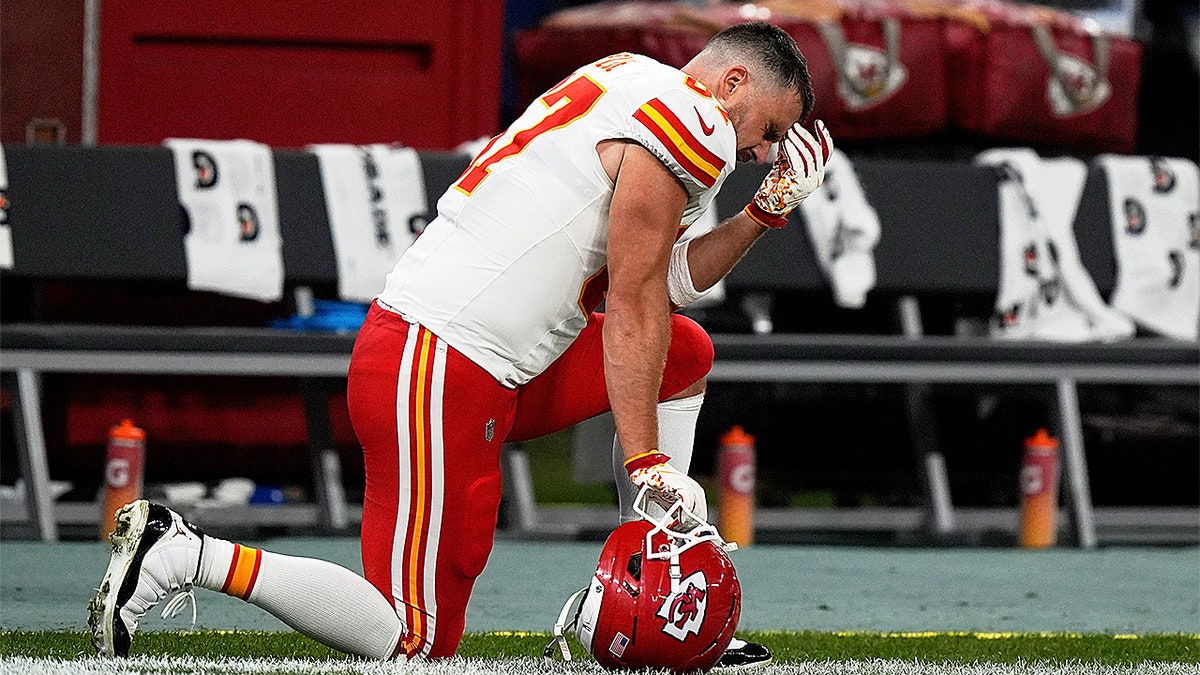 Travis Kelce kneels on the field after Kansas City's loss to the Chargers in São Paulo