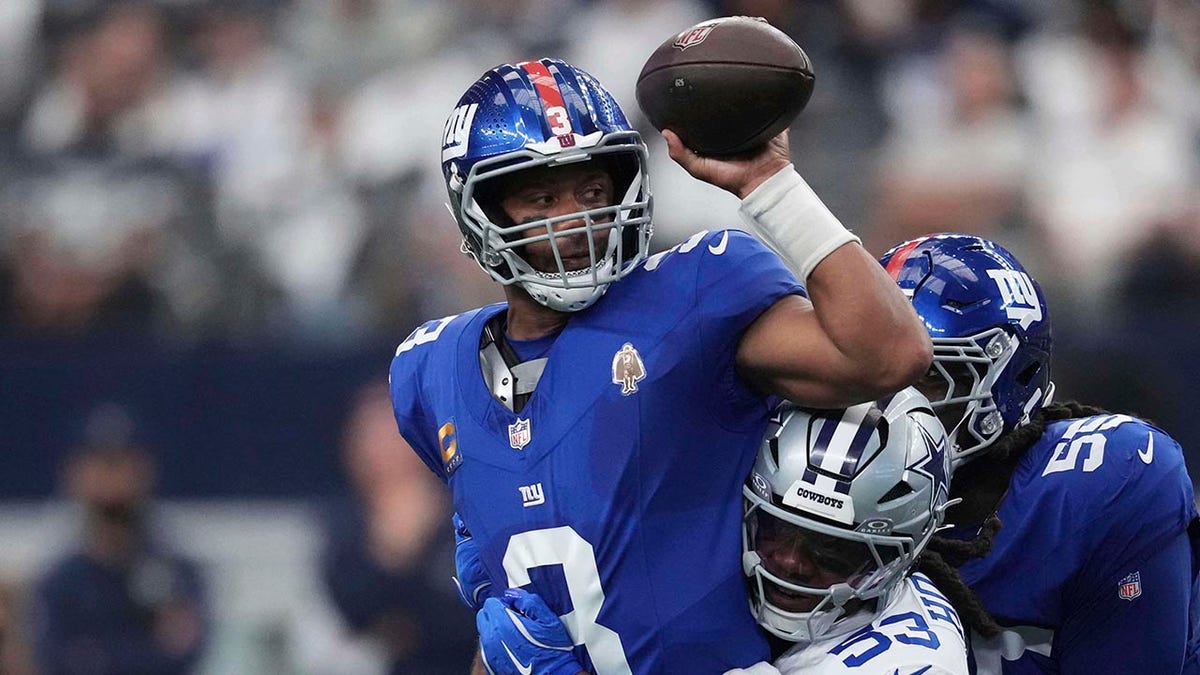 Russell Wilson attempts to escape a sack by James Houston