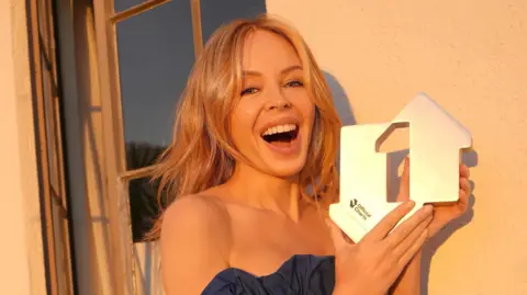Kylie Minogue claims Christmas number one with XMAS, first female artist to top four decades