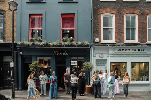 Closed barriers and a nearly empty platform at a London Underground station