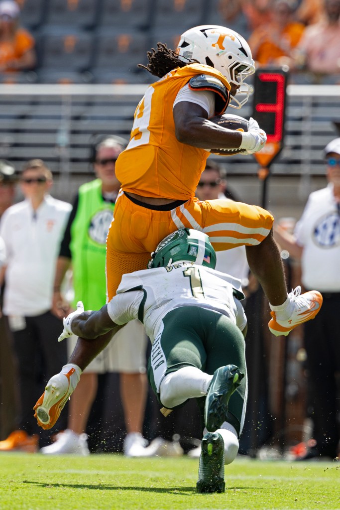 Star Thomas leaps to avoid tackle by Bryant