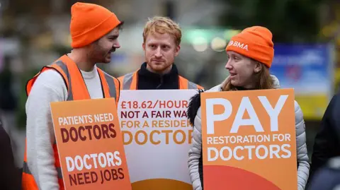 Resident doctors in England strike over pay and conditions as NHS winter pressures mount