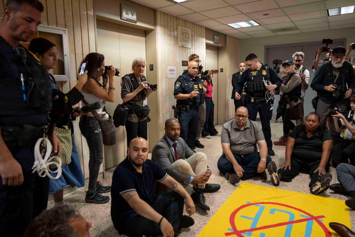 Sign showing a slash through the word ICE and protesters outside