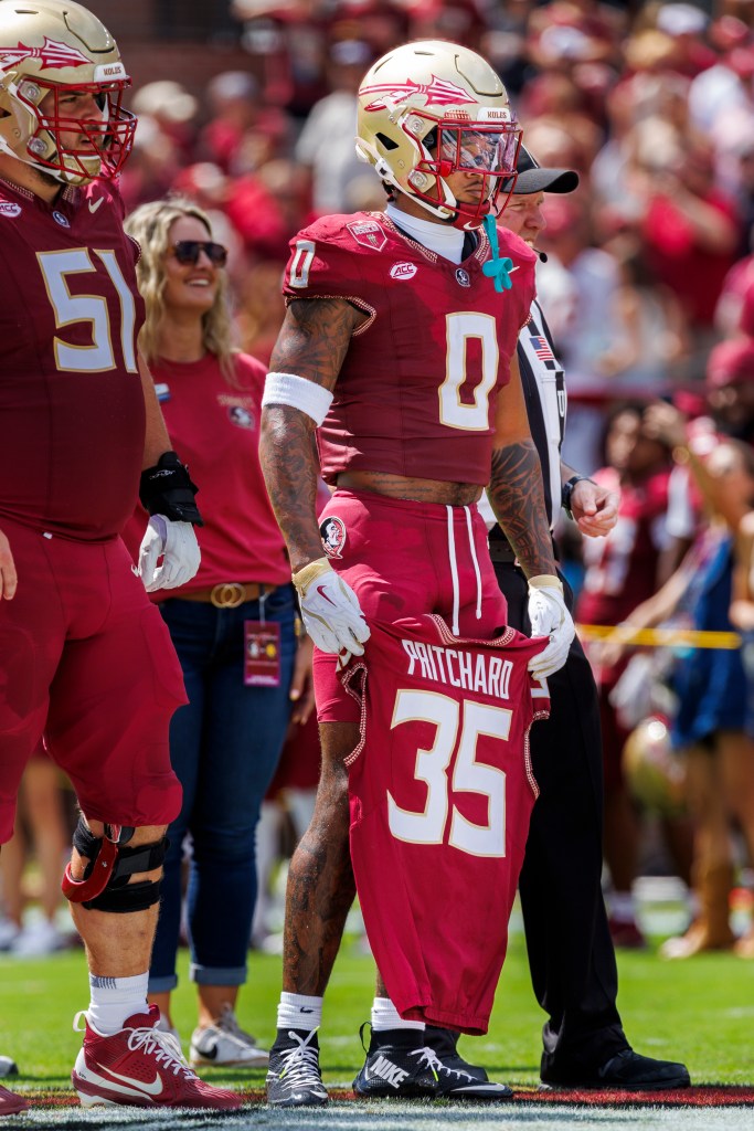 Earl Little Jr. holds Ethan Pritchard's jersey before a Florida State home game