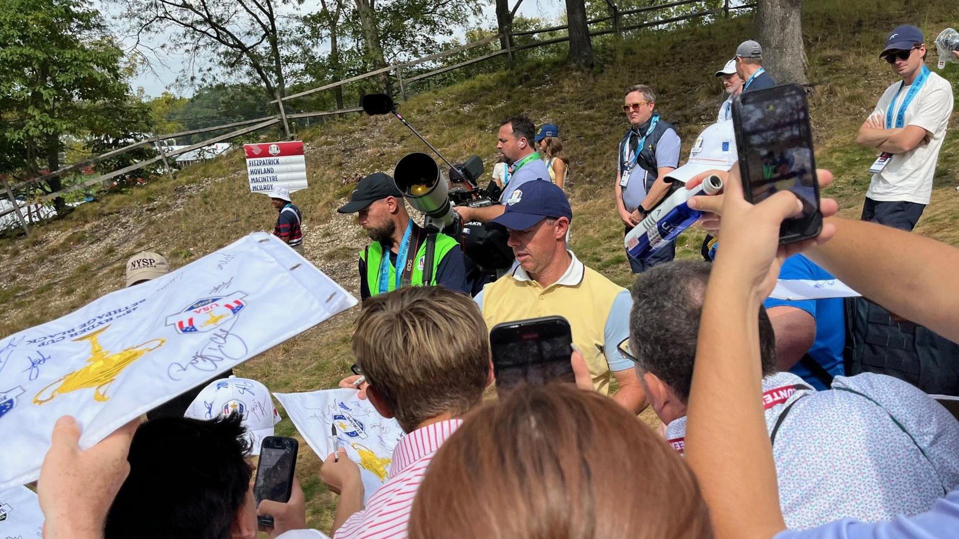 McIlroy and European teammates signing autographs during practice
