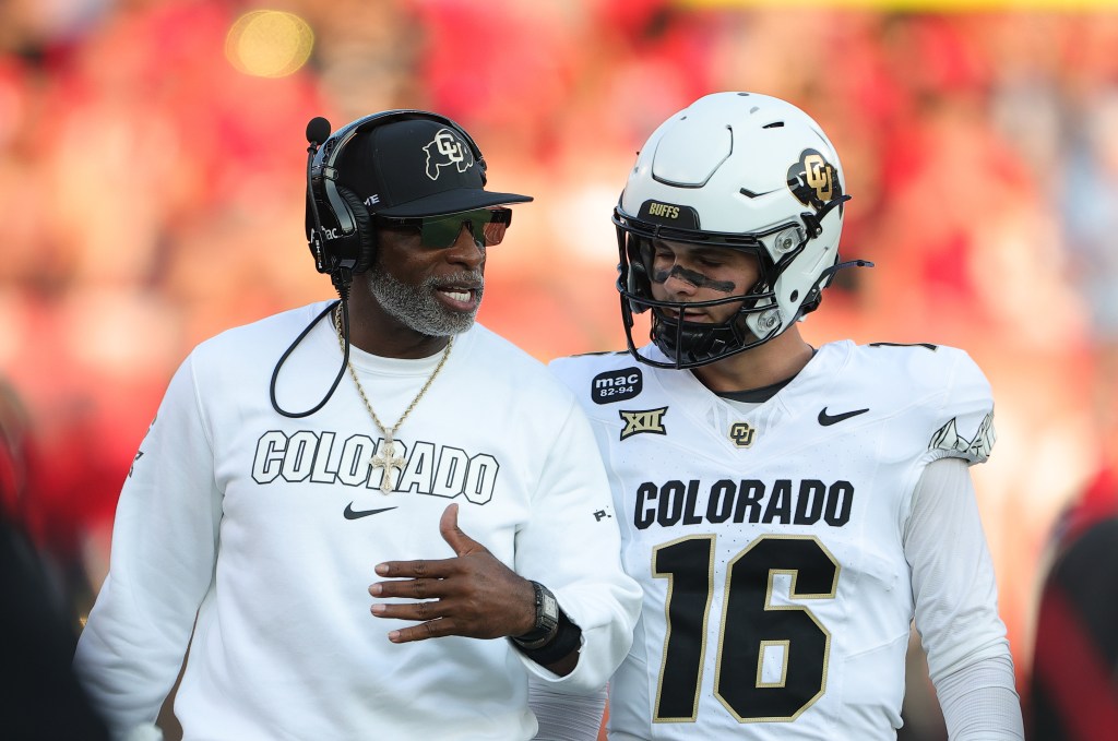 Deion Sanders speaks with Colorado quarterback Ryan Staub during the first half