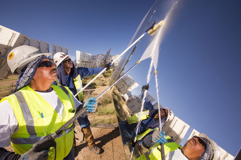 Workers washing heliostats