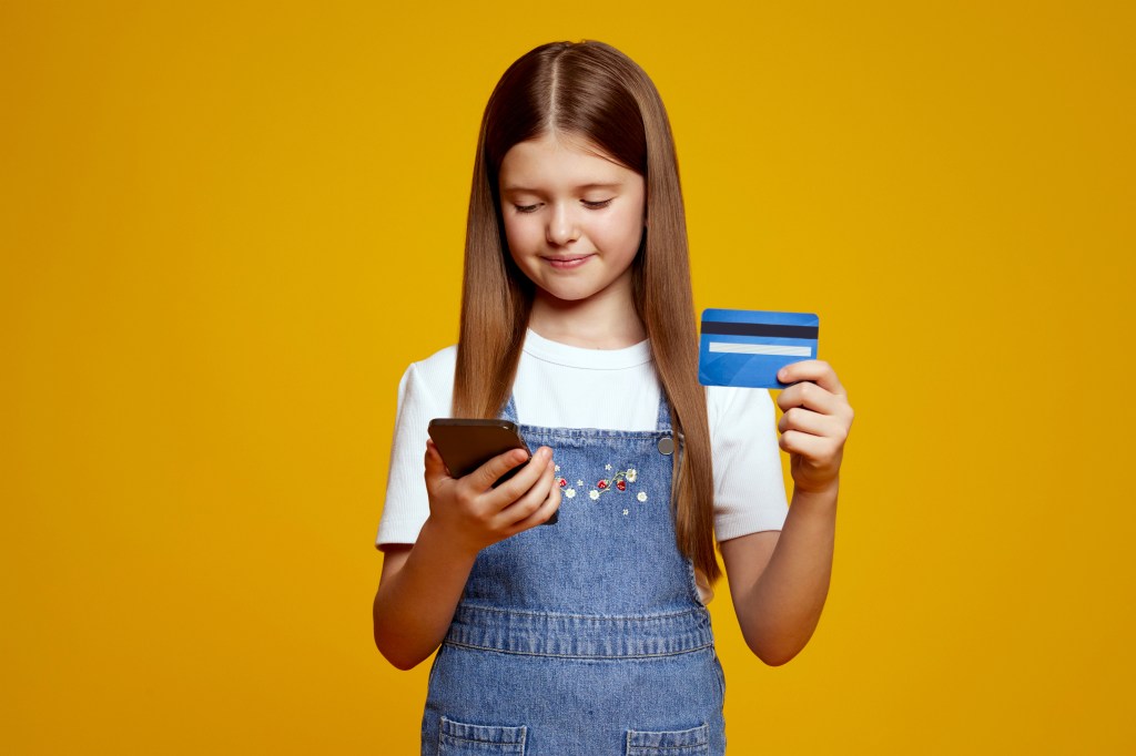 child with smartphone and credit card