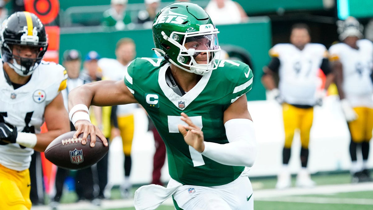 Justin Fields rolls out to pass for the Jets