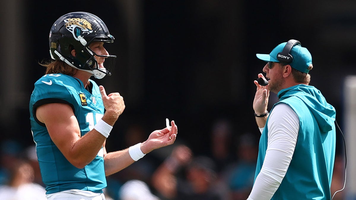 Trevor Lawrence and Liam Coen speaking on the sideline