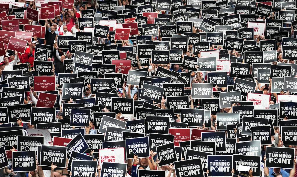 Attendees raise signs at memorial service