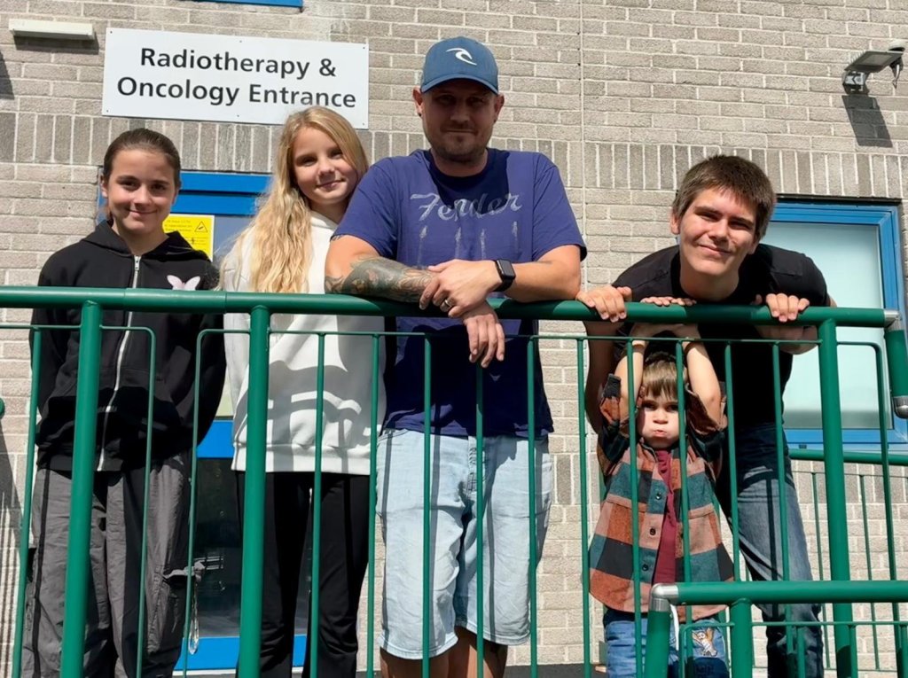 Paul Welsh-Dalton with his children beside a large green Lego dragon statue