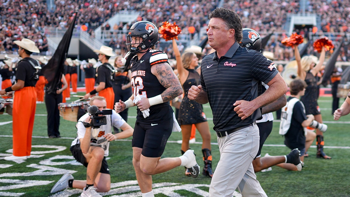 Mike Gundy runs on the field