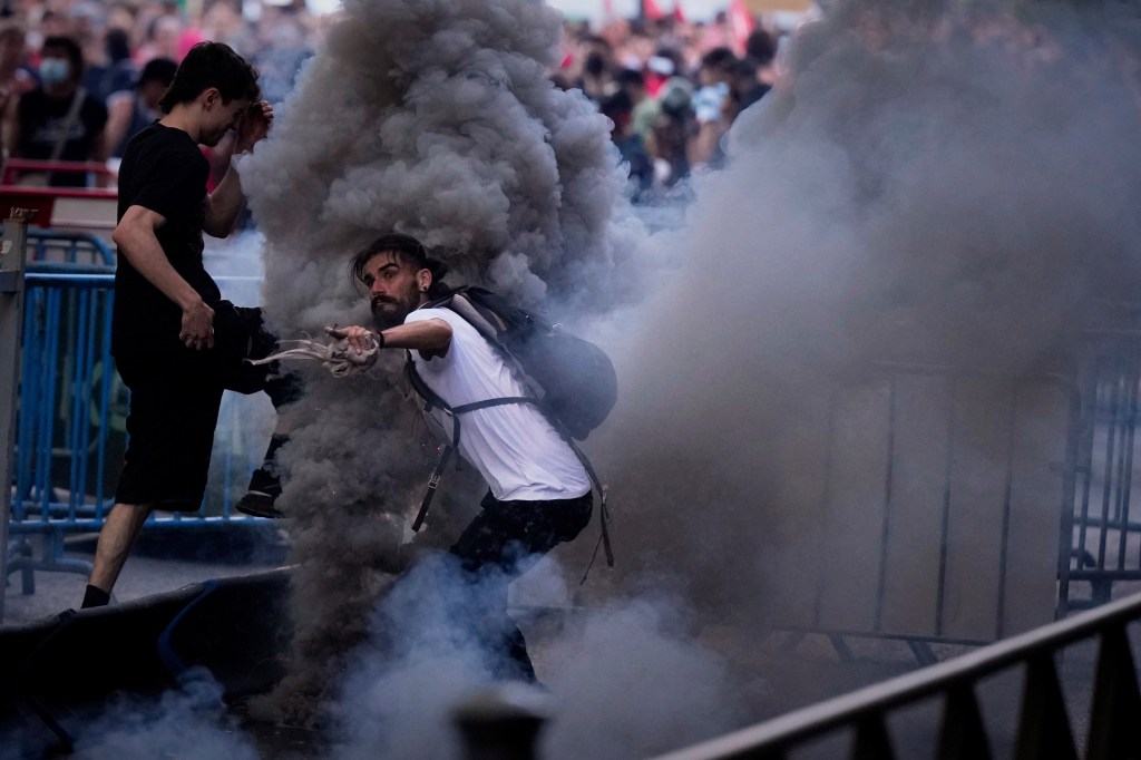 Police clash with protesters near the finishing circuit in Madrid