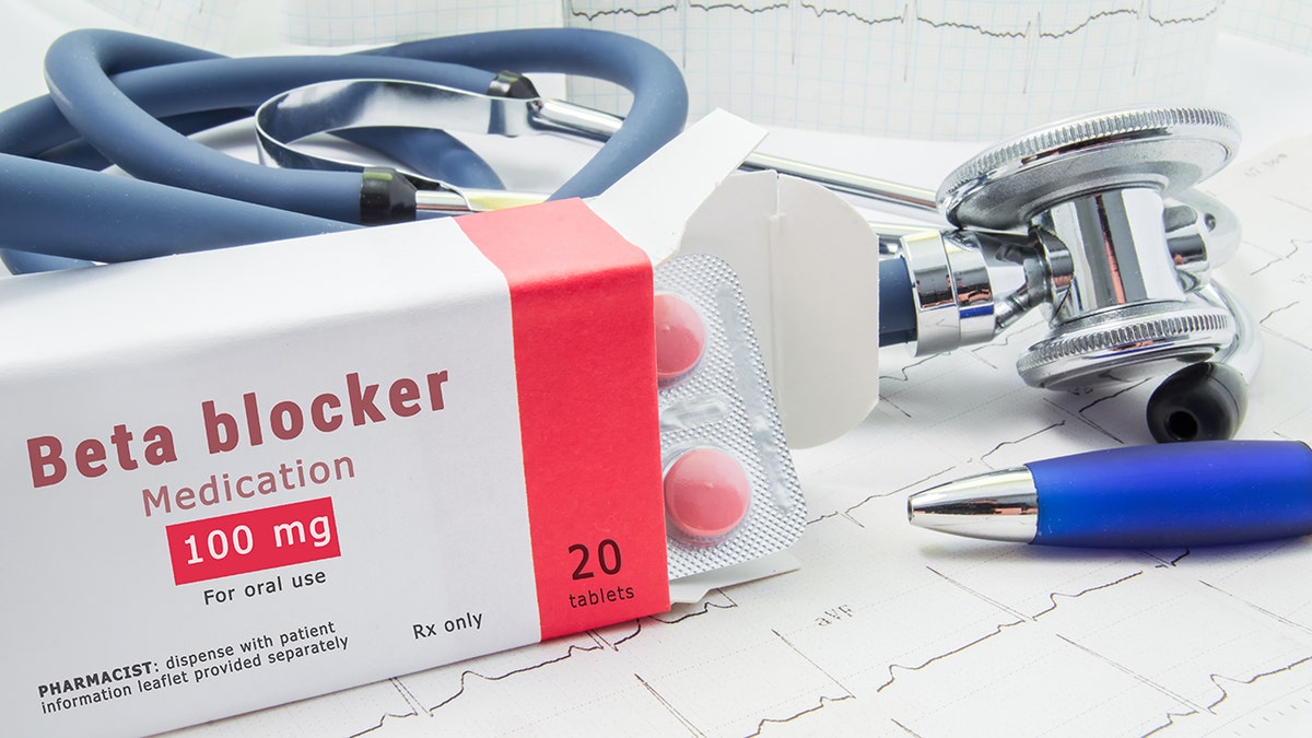 Woman taking medication with stethoscope nearby