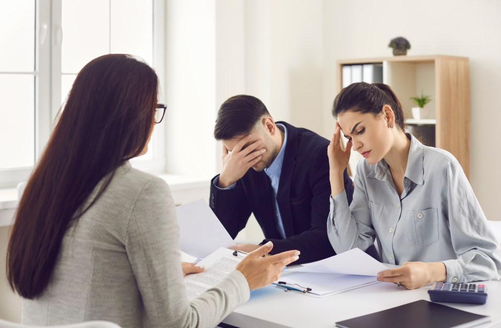 Couple reviewing financial documents at a kitchen table