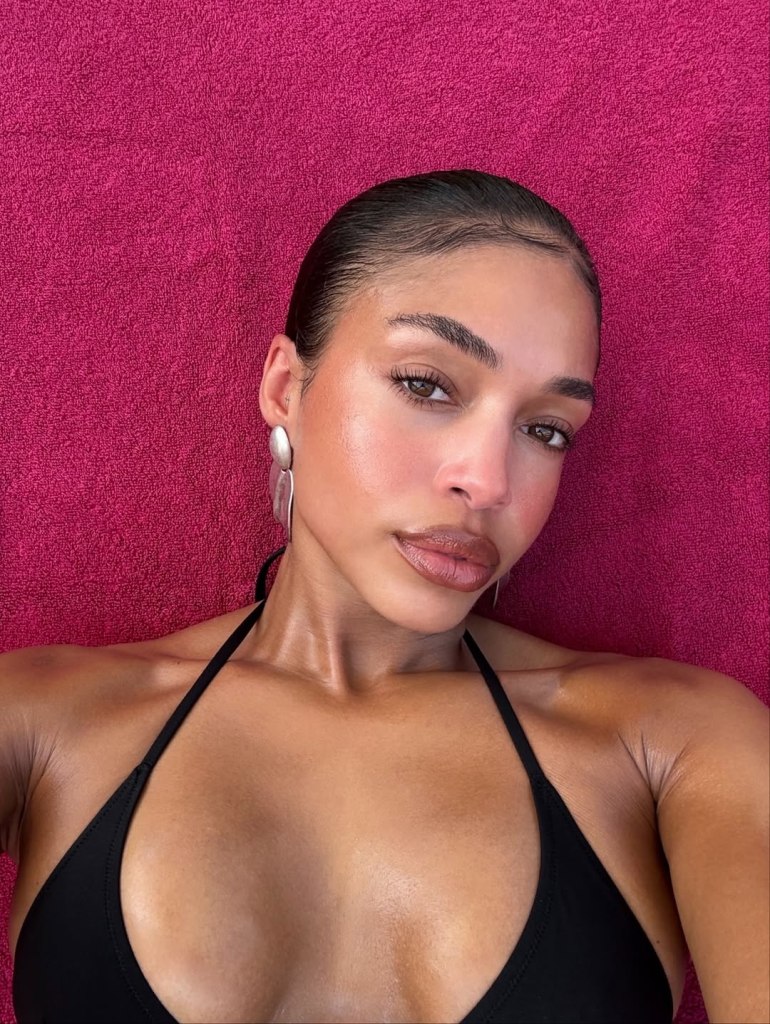 Lori Harvey lying on beach in zebra-print cover-up