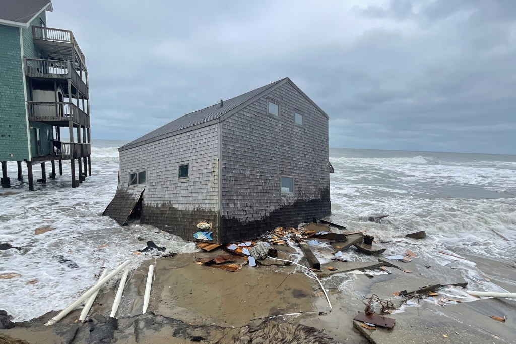 Collapsed cottage sits among waves