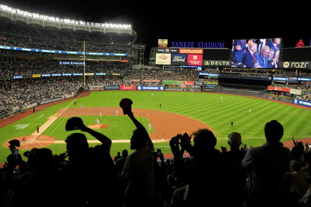 Fans at Yankee Stadium react as the president is shown on the video board