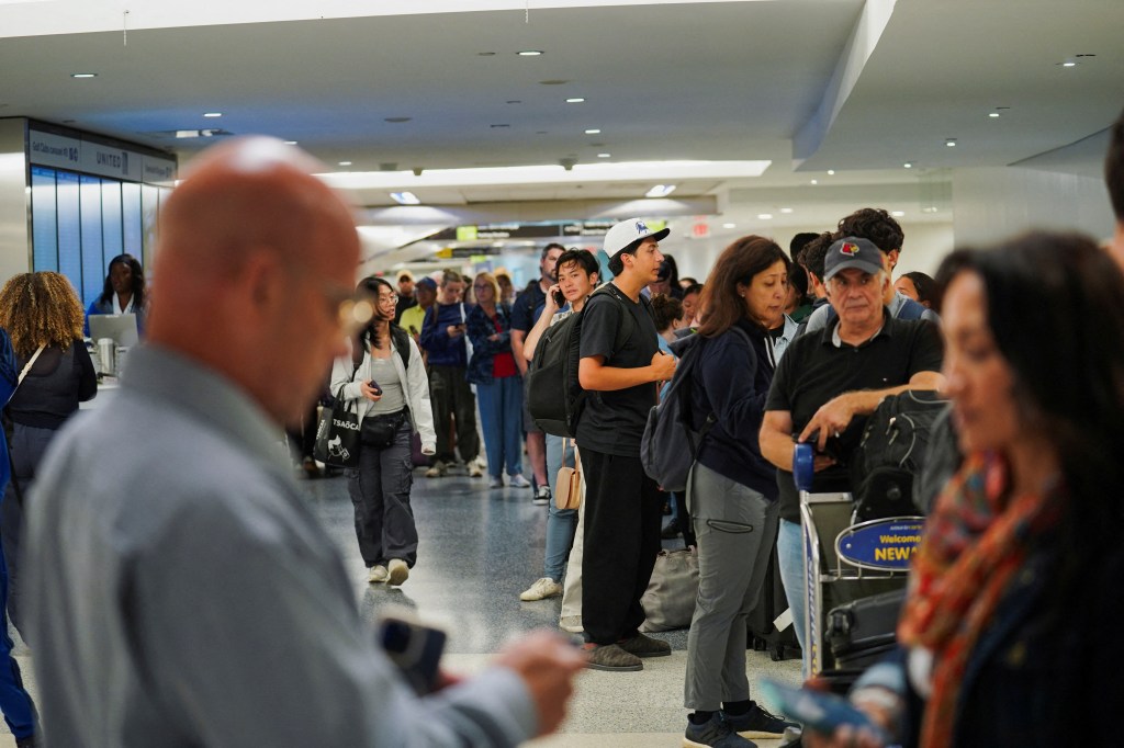 Travelers waiting in line for delayed luggage