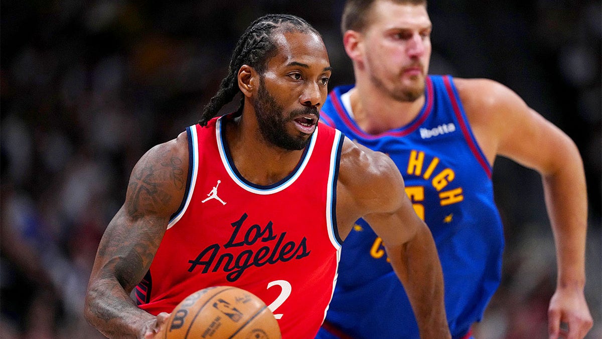 Kawhi Leonard dribbles past Nikola Jokić
