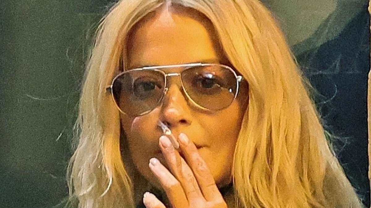 Rita Ora lights a cigarette outside Milan hotel after Prada show during Fashion Week